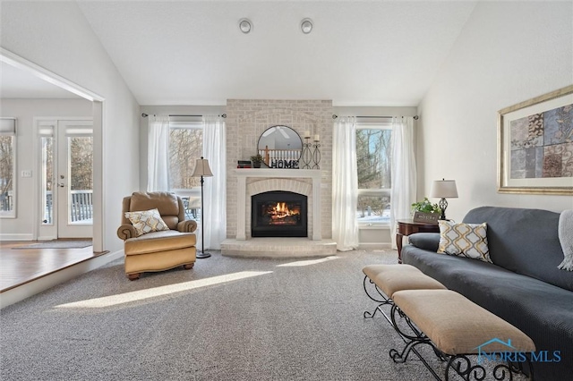 carpeted living room featuring lofted ceiling and a fireplace