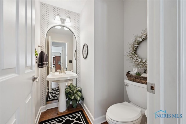 bathroom featuring hardwood / wood-style flooring and toilet