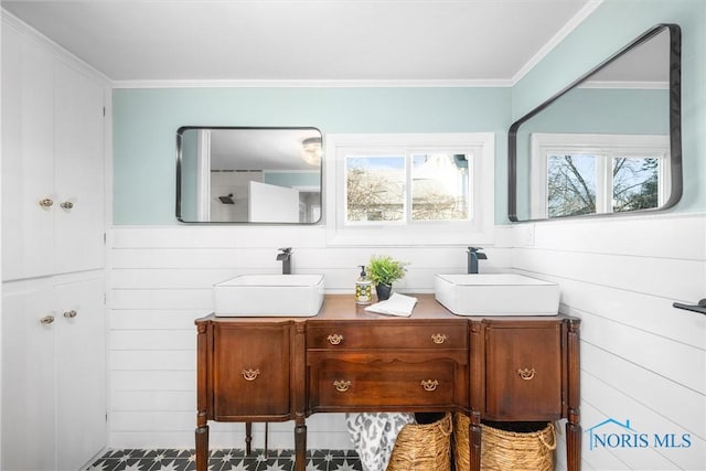 bathroom featuring ornamental molding, vanity, and wooden walls