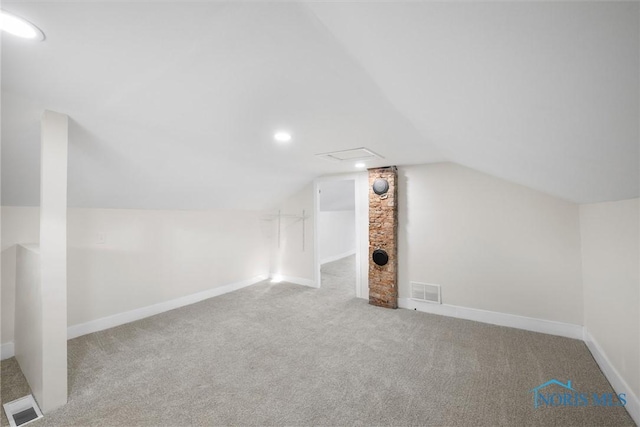 bonus room with light colored carpet and lofted ceiling