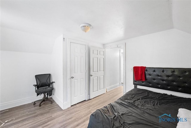 bedroom featuring vaulted ceiling and hardwood / wood-style floors