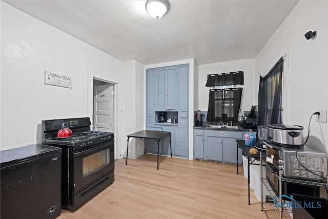 kitchen featuring gas stove, sink, and light hardwood / wood-style floors