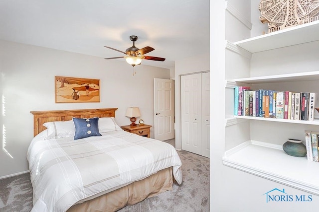 carpeted bedroom featuring ceiling fan and a closet