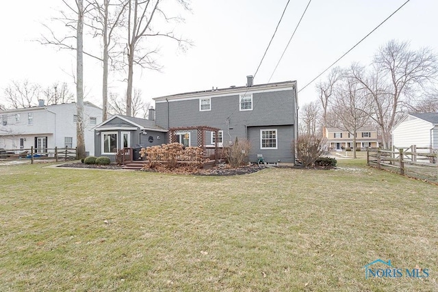 back of property with a yard, a pergola, and a deck