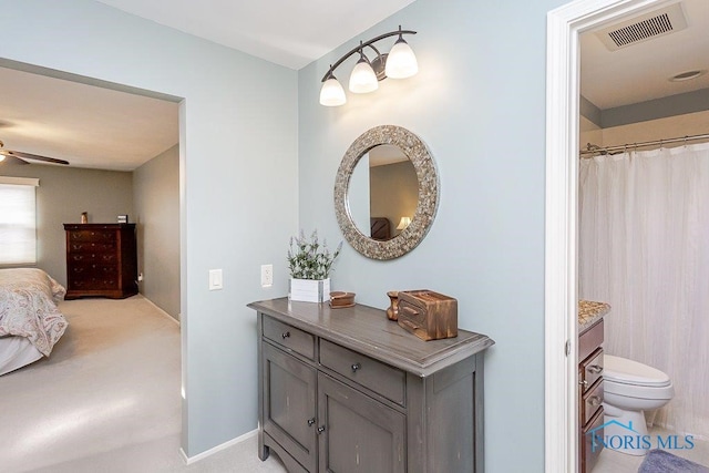 bathroom featuring vanity, toilet, and ceiling fan