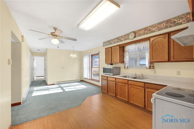 kitchen featuring sink, hanging light fixtures, light hardwood / wood-style flooring, a baseboard radiator, and white range with electric cooktop