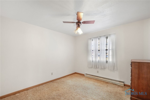 carpeted empty room featuring ceiling fan and baseboard heating