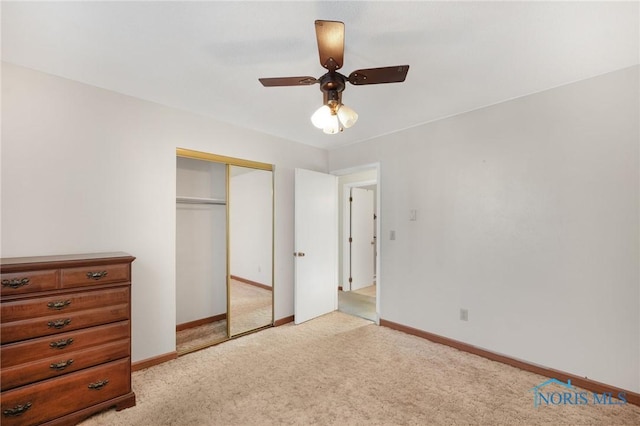 unfurnished bedroom featuring light carpet, a closet, and ceiling fan