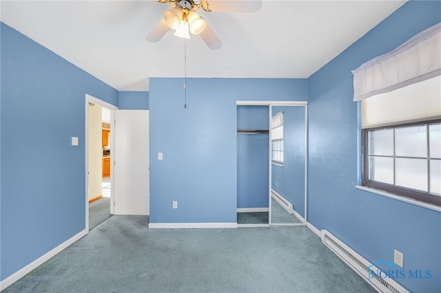 unfurnished bedroom featuring a baseboard heating unit, a closet, ceiling fan, and carpet flooring