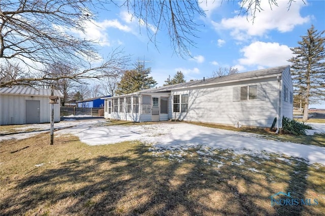 back of property featuring a sunroom and a lawn