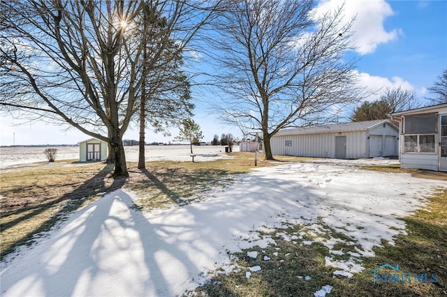 yard covered in snow featuring a sunroom and a storage shed