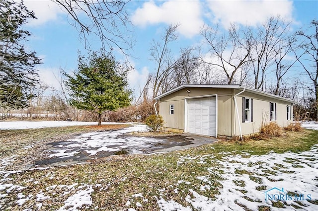 view of snowy exterior featuring a garage