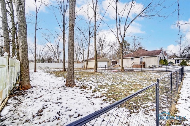 yard layered in snow with an outbuilding and a garage