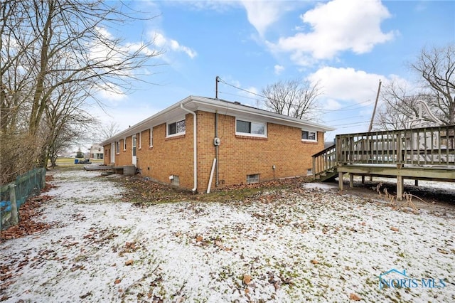 view of snowy exterior featuring a wooden deck