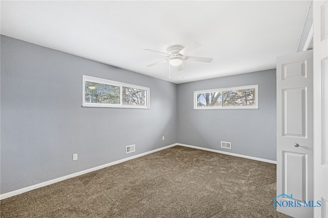 carpeted spare room featuring ceiling fan