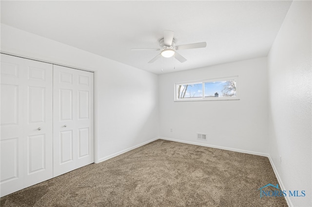 unfurnished bedroom with carpet floors, ceiling fan, and a closet