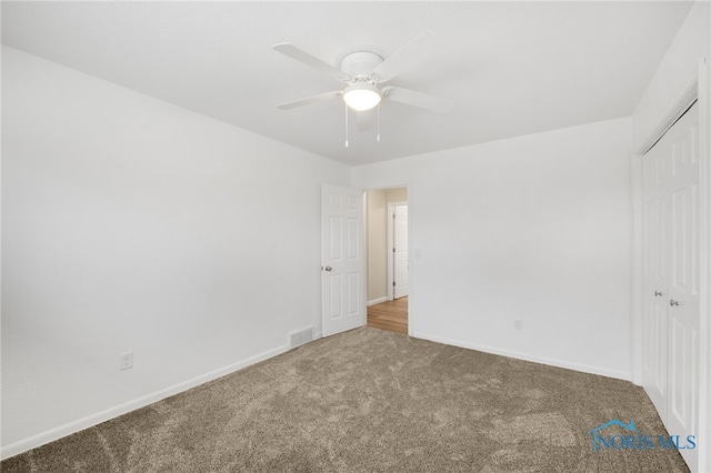 unfurnished bedroom with carpet flooring, ceiling fan, and a closet