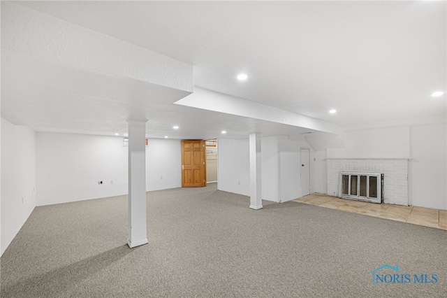 basement featuring a fireplace and light colored carpet