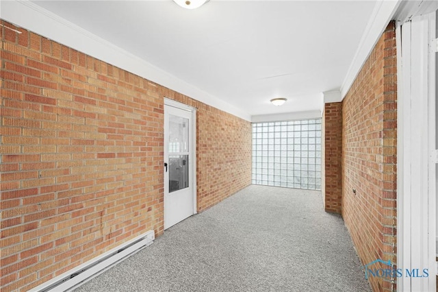 hall featuring a baseboard heating unit, crown molding, carpet, and brick wall