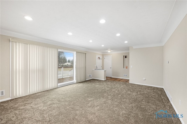 unfurnished living room with ornamental molding and carpet