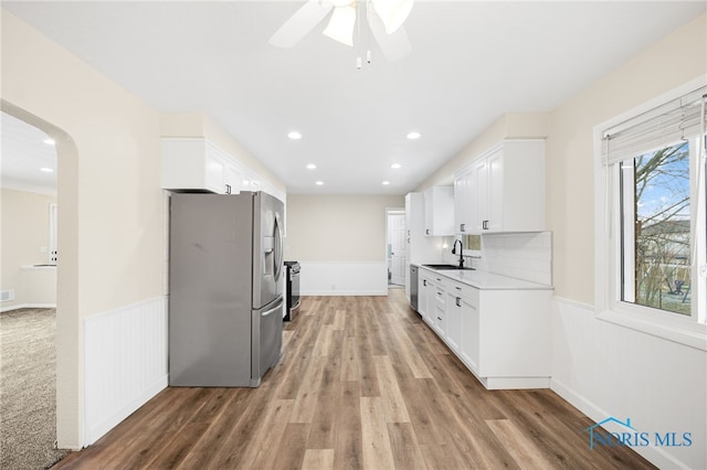 kitchen with white cabinetry, stainless steel appliances, sink, and wood-type flooring