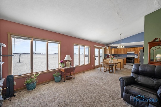 living room with lofted ceiling, light colored carpet, a water view, a textured ceiling, and a chandelier