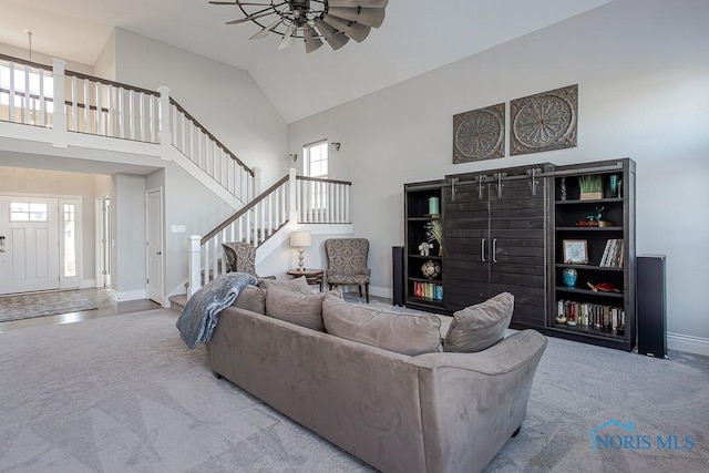 carpeted living room with high vaulted ceiling and ceiling fan