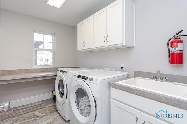 washroom featuring cabinets, sink, and washing machine and clothes dryer