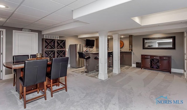 dining space with a paneled ceiling, light colored carpet, and decorative columns