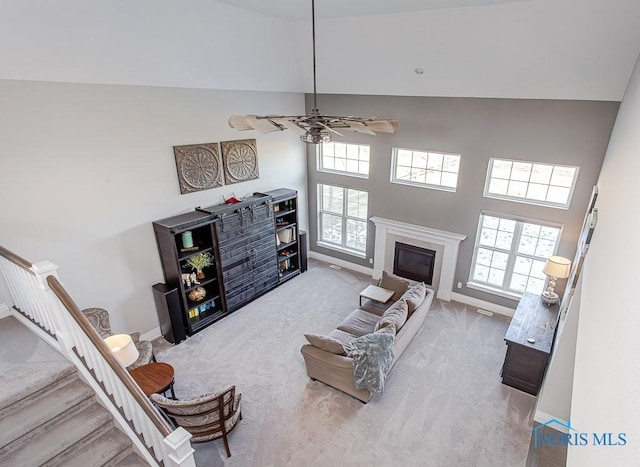 carpeted living room featuring high vaulted ceiling and ceiling fan