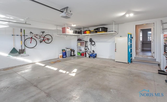 garage featuring a garage door opener and refrigerator