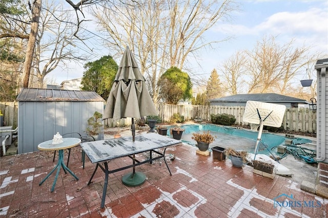 view of patio with a covered pool and a storage unit