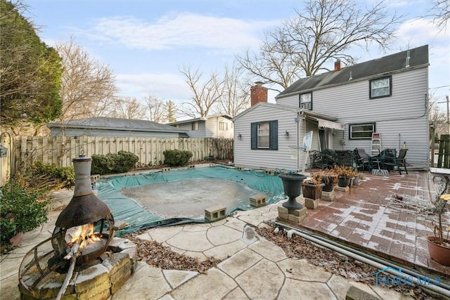 rear view of house featuring a patio and a covered pool