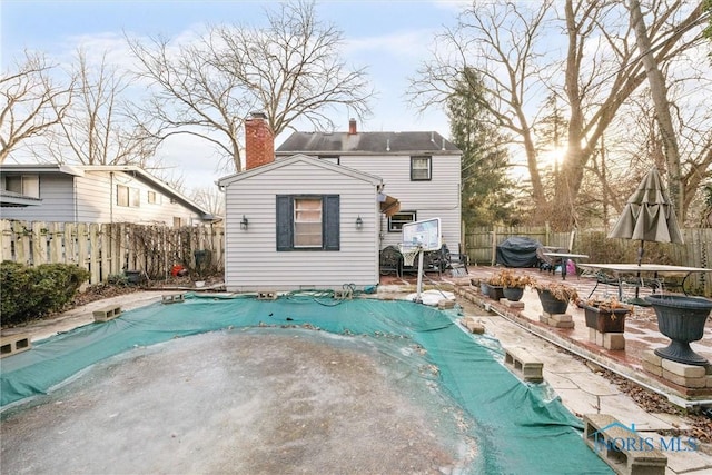 back of property featuring a covered pool and a patio