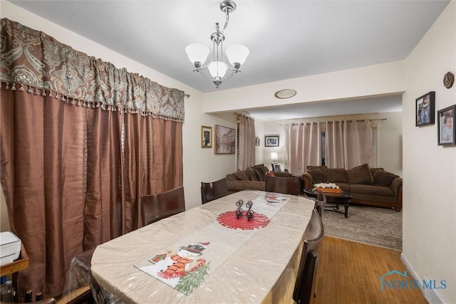 dining room with hardwood / wood-style flooring and a notable chandelier