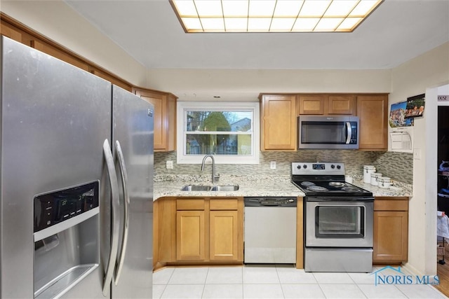 kitchen featuring tasteful backsplash, stainless steel appliances, light tile patterned flooring, and sink