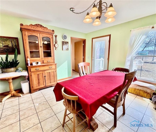 dining space with light tile patterned floors and a chandelier