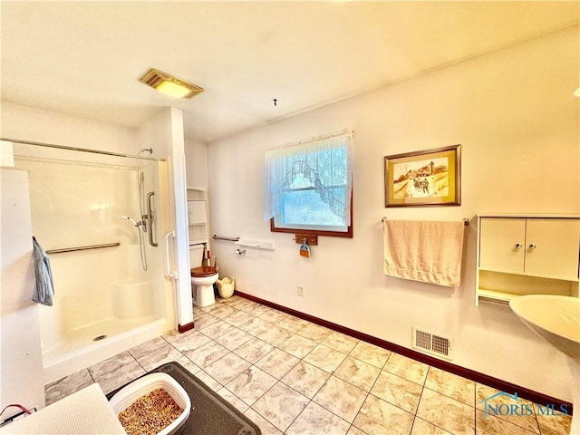 bathroom featuring tile patterned floors, a shower, and toilet