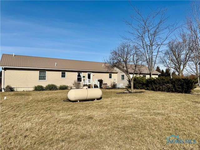 back of property with a yard and central AC unit