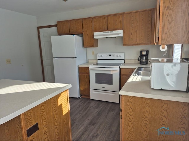 kitchen featuring white appliances, dark hardwood / wood-style flooring, and sink