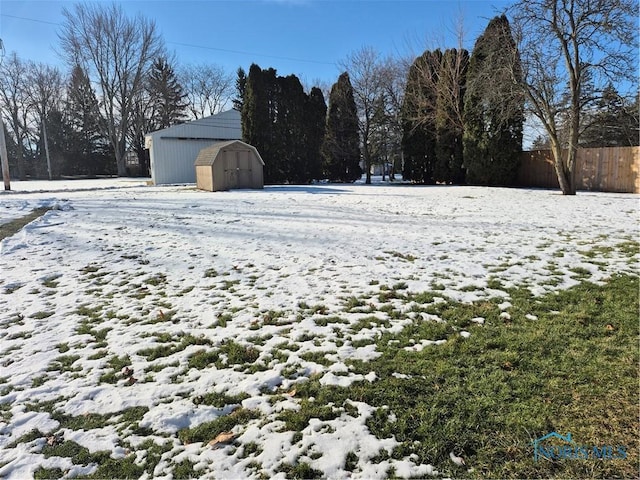 yard covered in snow with a shed