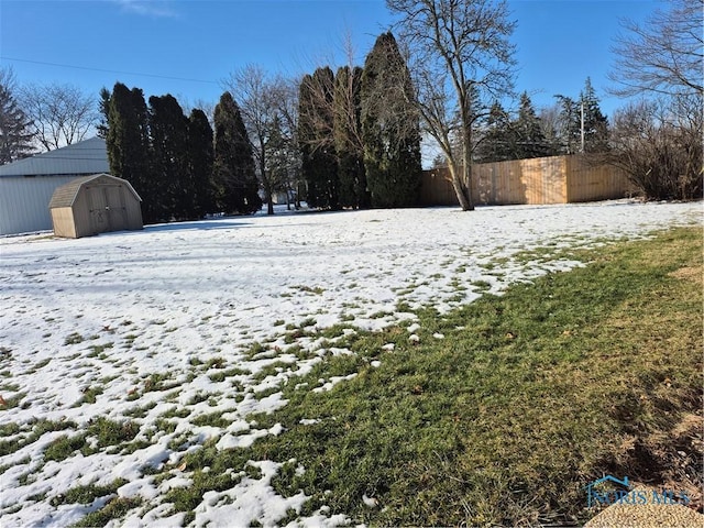 yard covered in snow featuring a storage unit