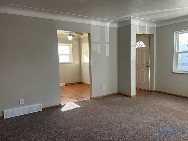 carpeted spare room with ceiling fan and a healthy amount of sunlight