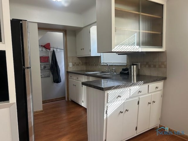 kitchen featuring white cabinetry, sink, dark hardwood / wood-style flooring, and tasteful backsplash