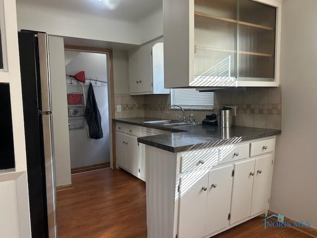 kitchen with white cabinetry, sink, dark wood-type flooring, and decorative backsplash