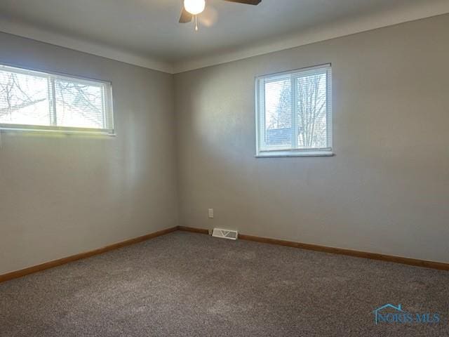 carpeted spare room featuring ceiling fan