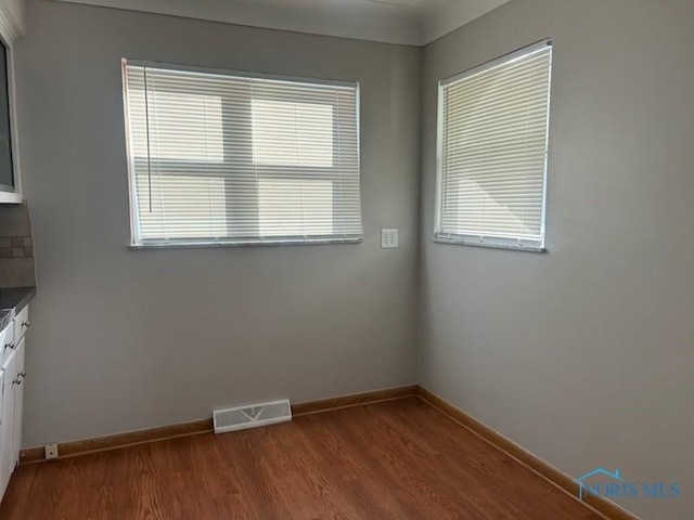 unfurnished room with a wealth of natural light and wood-type flooring