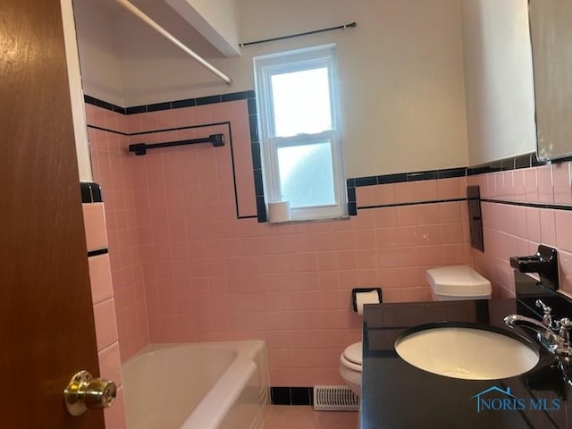 full bathroom with washtub / shower combination, toilet, and tile walls