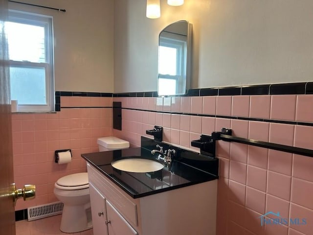 bathroom with tile patterned flooring, vanity, tile walls, and toilet