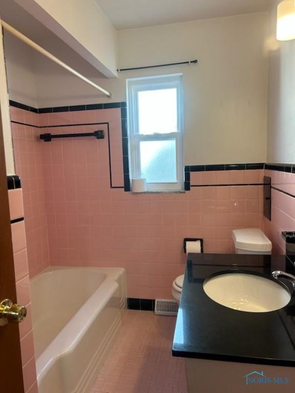 full bathroom featuring vanity, shower / washtub combination, tile walls, and toilet